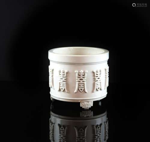 A white monochrome incense burner of cylindrical form, decorated on the exterior with a number of