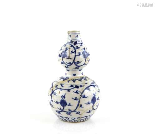 A blue and white vase of double gourd form, decorated with formal lotus and scrolling motifs; the