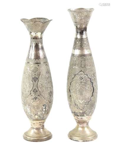 An associated pair of white metal vases; each one decorated with floral designs, probably Persian