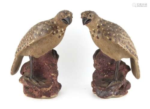 Property of a lady - a pair of early 20th century Japanese pottery models of perched hawks,