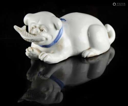 A Japanese Hirado model of a recumbent puppy holding a fish in its mouth, late 19th / early 20th