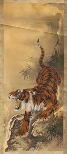 An early 20th century Japanese scroll painting on silk depicting a tiger by a stream, signed &