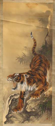 An early 20th century Japanese scroll painting on silk depicting a tiger by a stream, signed &