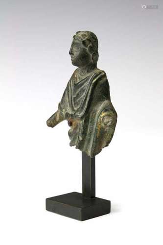 Roman bronze fragment of a man in toga, ca. 1st century.wearing a laurel wreath and with remnants of