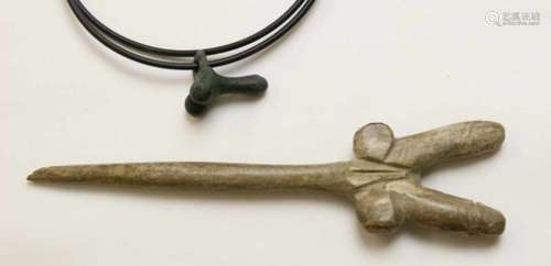 Carved antique bone pin and a bronze antique amulet;in the shape of a double phallus and small