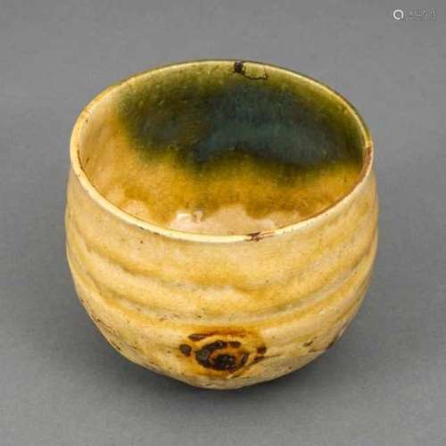 Ki-Seto or ao-Oribe ware chawan with ochre glaze and two dark brown flowers, on one side with