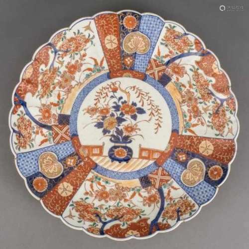 Large porcelain Imari dish with contoured edge, central with a flower vase motif, the cartouches