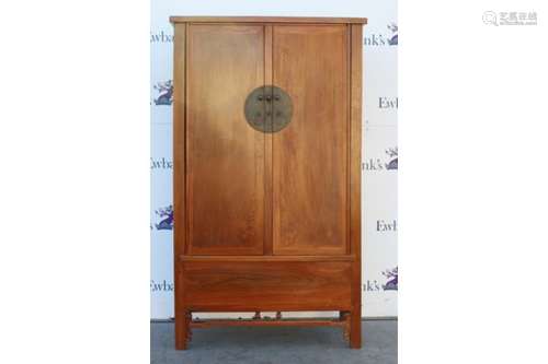 A Chinese wood cabinet of approximately trapezoid form, with two hinged doors and central metal lock