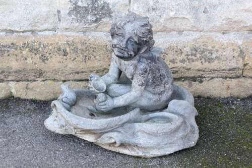 Antique Lead Garden Ornament; the ornament depicting a seated cherub, approx 50 x 52 cms