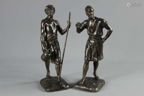 A Pair of Patinated Metal Figures; the figures of Nubian Natives, set on square bases with signatures, both approx 31 cms h