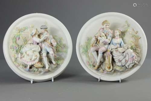 Two Porcelain Wall Plaques; the plaques depicting classical scenes in relief, approx 26 cms dia