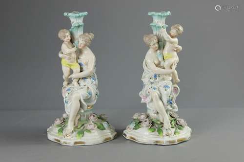 Two Continental Porcelain Candle Sticks; the ornate candle sticks depicting a mother and infant, with applied floral decoration to base, approx 30 cms h, marks to base