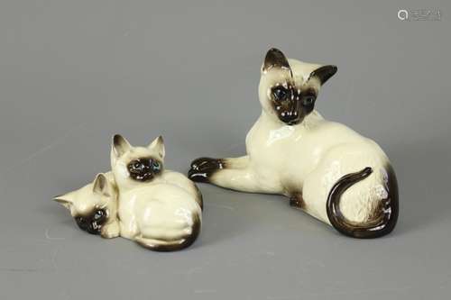 A Royal Doulton Porcelain Siamese Cats; the mother cat observing her two kittens, mother approx 19 x 12 cms, kittens approx 11 x 8 cms