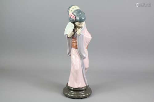 Lladro Figurine of a Japanese Geisha, shielding her face behind her fan, approx 30 cms h, impressed marks to base 4990, presented in the original box