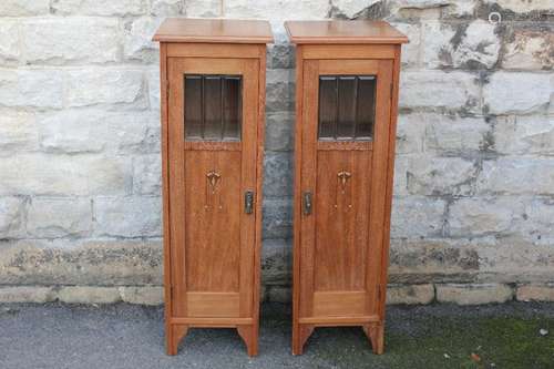 A Pair of Arts & Crafts Mahogany Cabinets; the inlaid cabinets with bevelled glass panels to front doors, having two shelves to interior, approx 36 x 35 x 113 cms