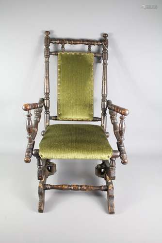 An American Made Child's Rocking Chair; the chair having moss green fabric covering back and seat, turned arms, legs and stretchers, approx 42 x 46 x 68 cms h