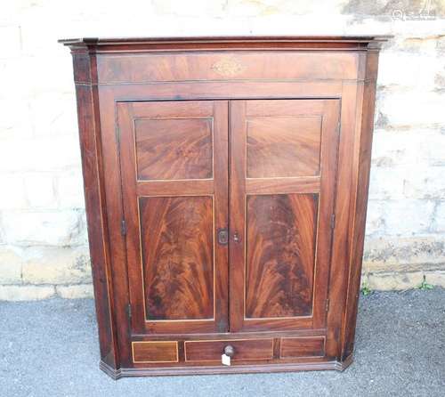 An Antique Mahogany Corner Cupboard, the cupboard having a decorative inlaid oval motif depicting Britannia, with fitted interior behind a double cupboard arrangement with single drawer beneath, approx 67 d x 105 w x 121 h