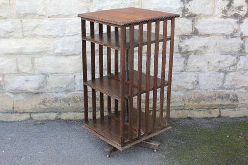 An Edwardian Oak Revolving Book Case; the unit having slats to two sides, two shelves on two sides, approx 54 x 51 x 105 cms