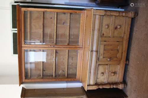 A Pine Sideboard; the sideboard having six drawers, central cupboard, turned leg supports to the sides, on bun feet, approx 142 x 35 x 81 cms, together with a pine glazed front display unit with four shelves, approx 144 x 22 x 116 cms