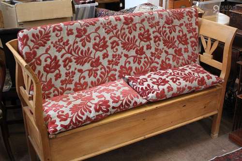 A Pine Kitchen Bench, the bench having a storage area beneath the seat, decorative leaf design to slat back and sides, approx 153 x 94 x 92 cms