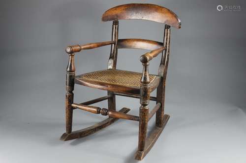 A Child's Antique Rocking Chair; the chair having a rattan seat, stretchers, arms turned at the ends, approx 38 x 48 x 58 cms