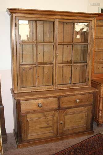 A Vintage Pine Dresser; the dresser having two glazed-front cupboards which open to reveal three plate shelves, two short drawers and two pot cupboards beneath, approx 132 w x 48 d x 192 cms