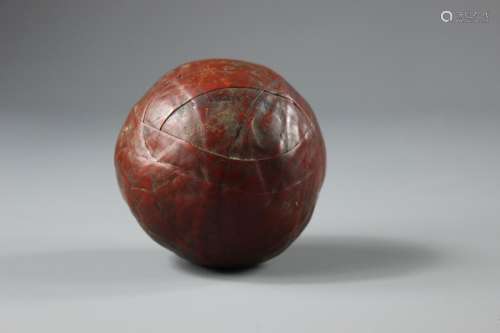 An Antique Red Leather Ball; the ball approx 7 cms dia,, with no visible stitching having a 