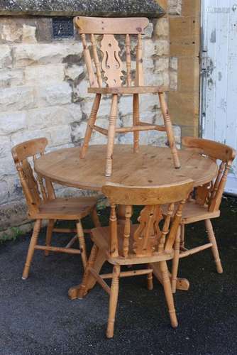 A Pine Circular Table and Four Chairs; the table having central pedestal on three legs, approx 107 cms dia, the four chairs having decorative backs with turned legs and stretchers