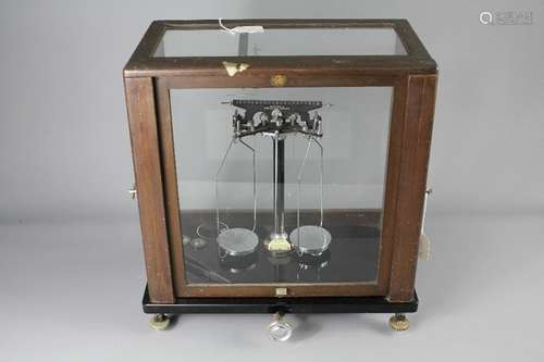 A Vintage Baird & Tatlock (London), nr 2100 Vintage Medical Balance, housed on black marble base in a glass case with two weights, a glass disc and tweezer, approx 40 x 23 x 46 cms