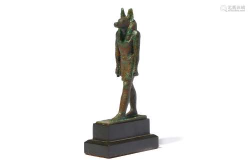 AN EGYPTIAN BRONZE FIGURE OF STRIDING ANUBIS