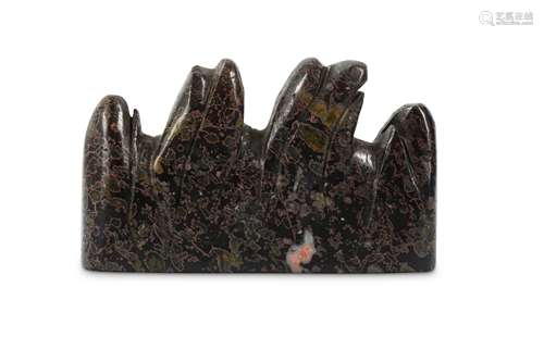 A CHINESE DREAMSTONE BRUSH REST. Carved with three peaks, the black stone with pink, white and green