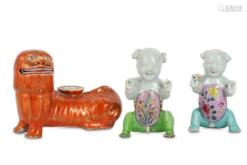 TWO CHINESE FAMILLE ROSE FIGURES AND AN IRON-RED 'LION DOG' CANDLE STICK.