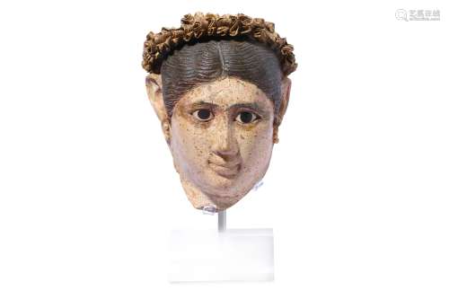 AN EGYPTIAN STUCCO PAINTED HEAD OF A WOMAN