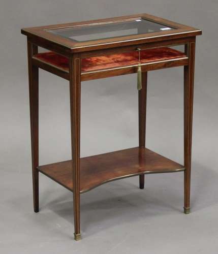 An Edwardian brass mounted rosewood bijouterie table, the hinged lid with bevelled glass, raised