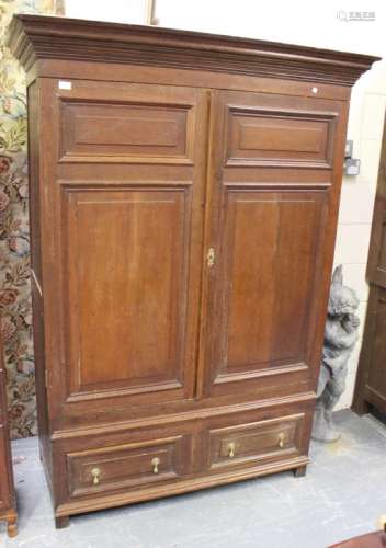 An 18th century Continental oak cupboard, the moulded pediment above a pair of fielded panel doors