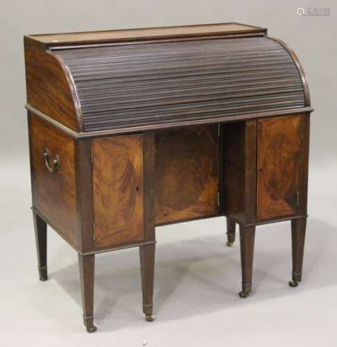 A late George III mahogany roll-top desk, the tambour shutter enclosing a gilt-tooled leather