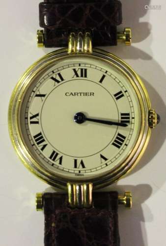 A Cartier Quartz gold circular cased lady's wristwatch, the signed cream coloured dial with black