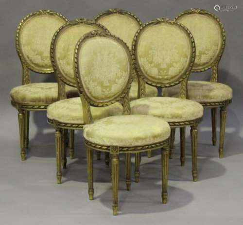 An early 20th century Louis XVI style giltwood framed nine-piece salon suite, comprising a tub