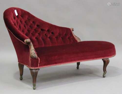 A late Victorian walnut framed chaise longue with carved decoration, upholstered in red velour, on