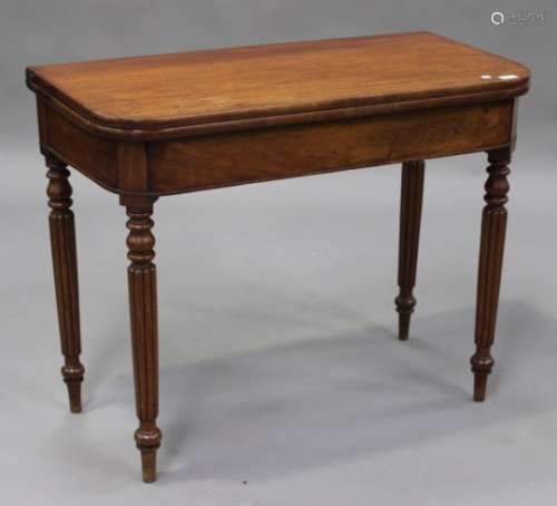 An early Victorian mahogany fold-over tea table, the hinged top raised on turned and reeded legs,