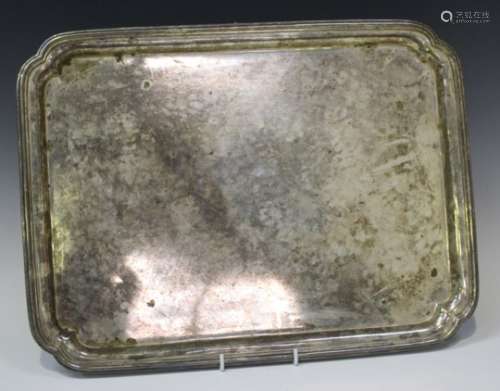 A George V silver rectangular tray with curved corners and raised rim, on bracket feet, London