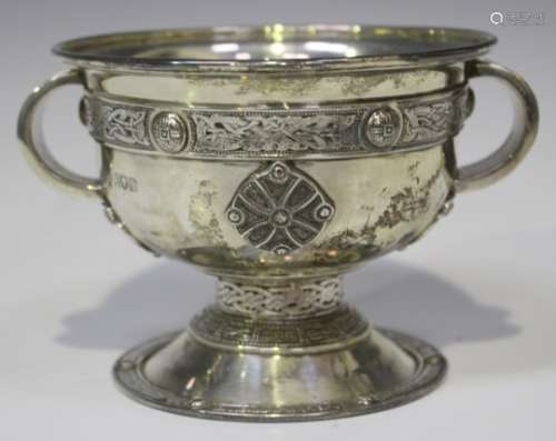 An Edwardian silver two-handled cup of squat circular form, decorated in relief with Celtic bands