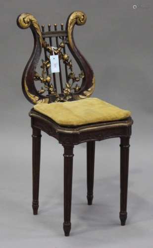 An early 20th century French mahogany music chair with gilt painted decoration, the carved lyre back