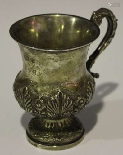 A mid-19th century silver christening mug, decorated with stylized palmettes and flowers, flanked by