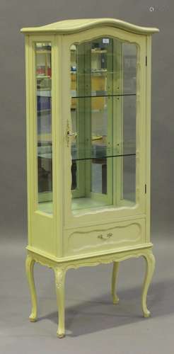 A late 20th century white painted vitrine, fitted with a glazed door and a drawer, on cabriole legs,