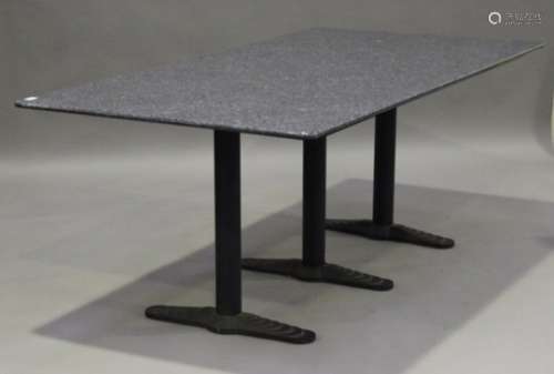 A modern granite-topped rectangular garden table, raised on three cast metal supports and stepped