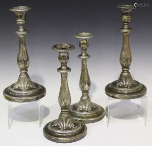 A set of four George III silver candlesticks, each with a detachable nozzle above a baluster stem