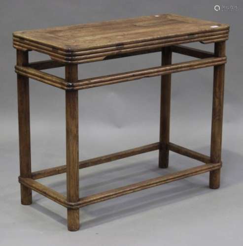 A 20th century Chinese elm table, the panelled top on turned legs united by stretchers, height 84cm,