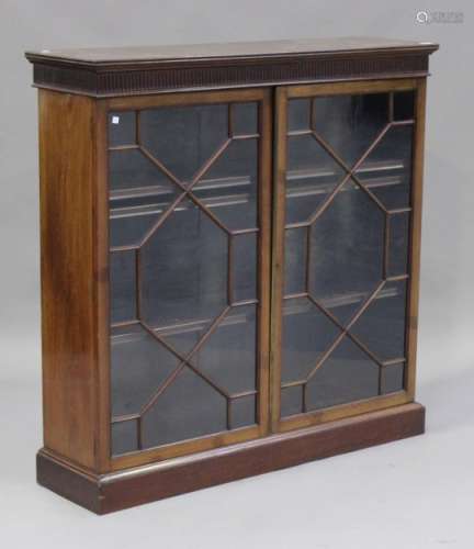 A George V mahogany bookcase the stop fluted frieze above two astragal glazed doors, on a plinth