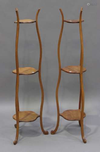 A pair of 20th century walnut three-tier jardinière stands, on shaped supports, height 134cm.Buyer’s
